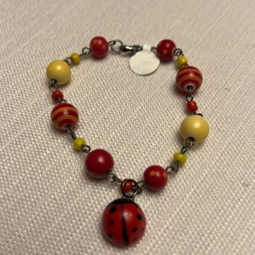 Handcrafted multicolor ceramic bracelet with lady bug charm. Such a fun piece!